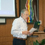 A man reads from a paper into a podium microphone